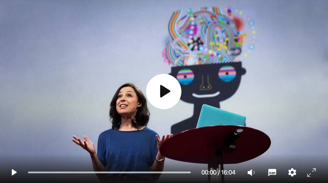 Woman in blue shirt with who appears to be giving a talk. There is a small 