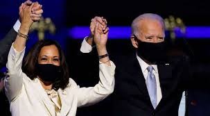 Joe Biden and Kamala Harris holding hands, hands raised in the air