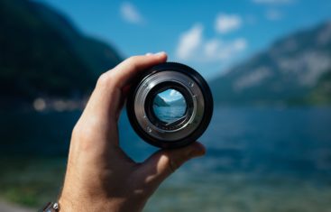 Looking through a camera lens to a mountain landscape