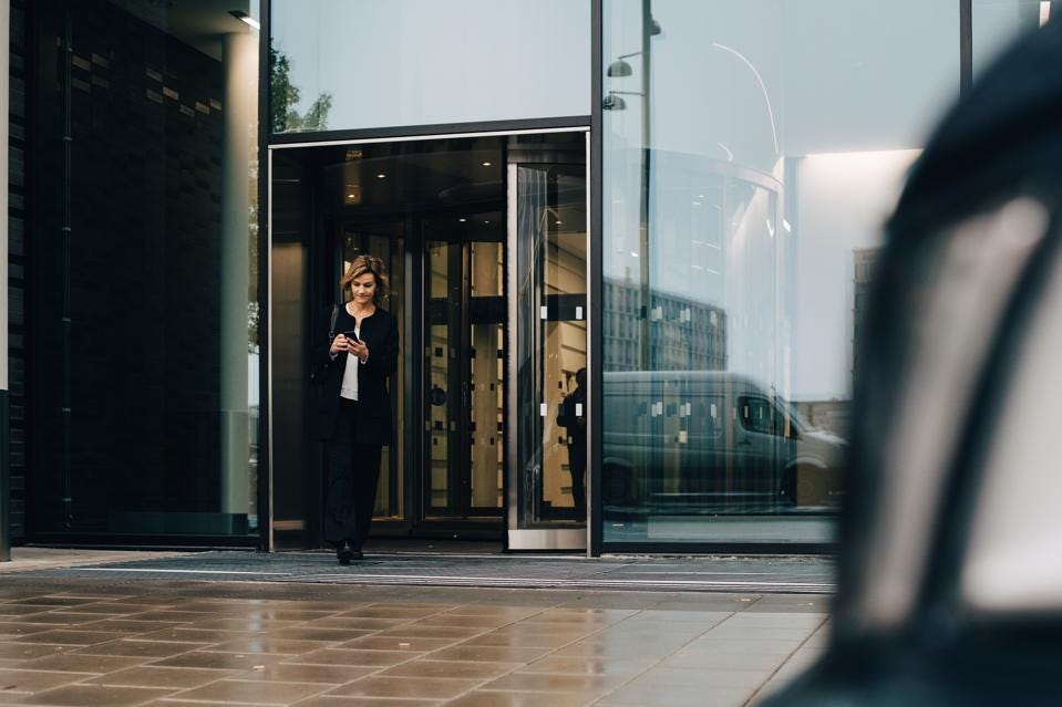 Person walking out of glass building